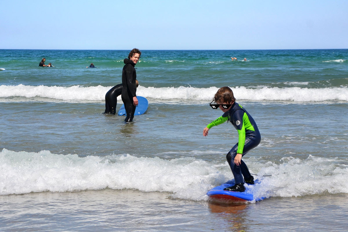 Premières mousses en redressement en autonomie pendant un cours surf collectif enfants